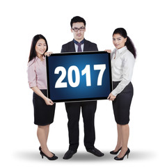 Canvas Print - Workers standing with 2017 on billboard