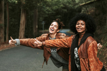 two girls making funny hitchhiking