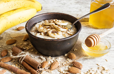 Wall Mural - oatmeal porridge with a spoon in ceramic bowl. healthy breakfast