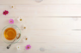 Fototapeta Nowy Jork - Green tea with daisies in a clear glass mug