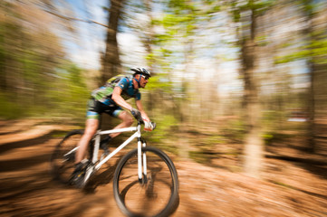 Man racing in a mountain bike panning motion