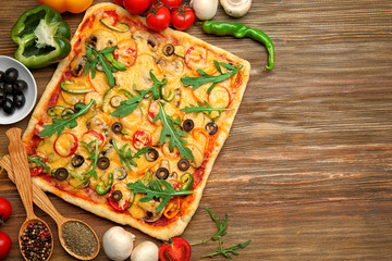 Wall Mural - Delicious pizza with ingredients on wooden background