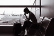 © kieferpix - Woman sitting at airport feeling unhappy and sad.