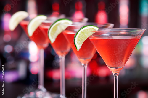 Fotomural Row of Cosmopolitan cocktails shot on a bar counter in a nightcl