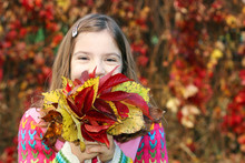 Little Girl Holding Colorful Autumn Leaves
