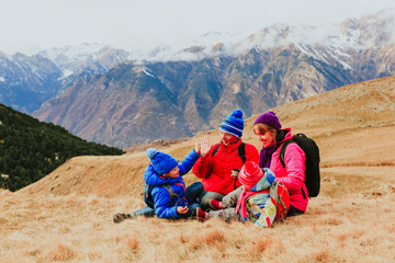 family with two kids travel in scenic winter mountains