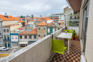 Balcony terrace view with Porto Oporto city house building background, table with two chair glass wine 