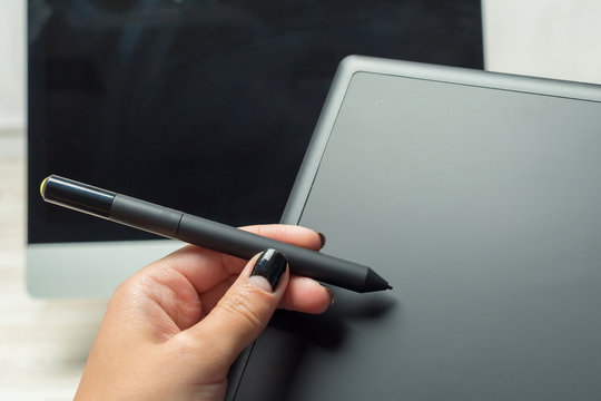 Hand of graphic designer working with stilus and tablet