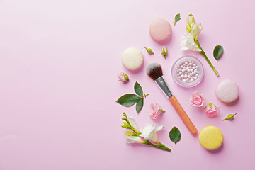 Wall Mural - Mineral powder with brush, macaroons and beautiful flowers on pink background