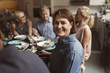 © Maskot - Portrait of happy mature woman sitting with friends at table