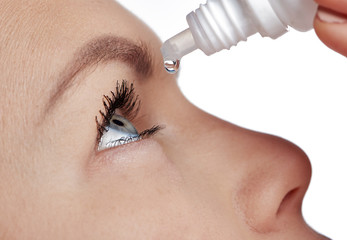 Close-up of young female using drops for tired and sick eyes. Concept of eye care, allergy treatment and medicine. 