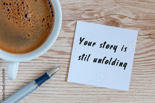 Fotografie, Obraz Your Story Is Still Unfolding motivation inscription at notepad near morning cup