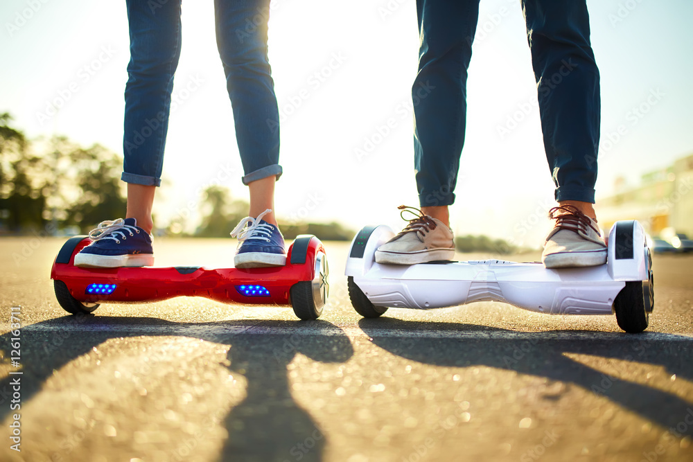 young man and woman riding on the Hoverboard in the park. content ...