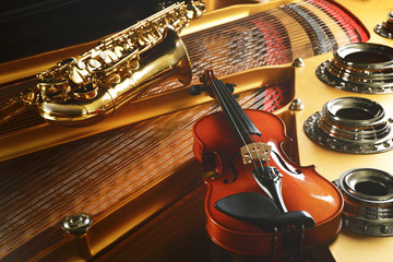 Canvas Print - Violin and saxophone lying on piano, close up