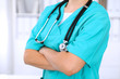 © rogerphoto - Female surgeon doctor is standing with arms crossed at hospital.  Physician  is ready to examine patient