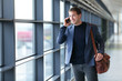 Smartphone business man talking on mobile phone in airport - travel lifestyle. Businessman using smartphone calling on phone walking in corporate building or on work commute in public transit area.