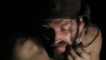 Scary Evil Sinister Bearded Man With Smirk, Holding A Bottle Of Vine And Glass. Strange Russian Man With A Naked Torso And A Woolen Hat