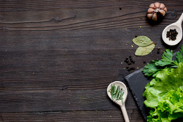 Wall Mural - spices and fresh salad on dark wooden table top view