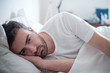 Leinwandbild Motiv Depressed man lying in his bed and feeling bad