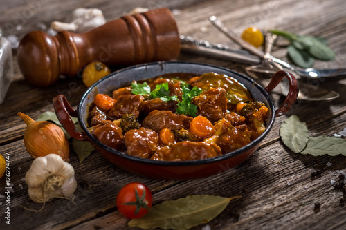 Fotografie, Obraz Meat stew with vegetable on rustic wooden background