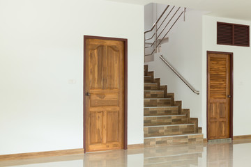 white empty room interior with wooden door and staircase