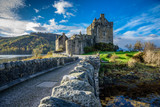 Majestic Eilean Donan castle on beautiful autumn day - with sunny foreground, dramatic sky and amazing scenery
