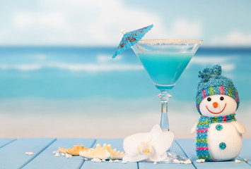 Cocktail, snowman, starfish and orchid flower on background of sea.