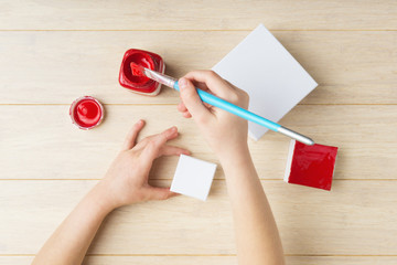 Wall Mural - Flat lay of elementary age woman hands during gift box painting