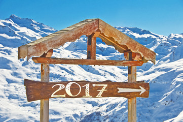 Wall Mural - 2017 written on a wooden direction sign, snow mountain landscape on the background