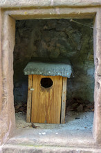 Patterned Wooden Birdhouses Stand In A Stone Cave
