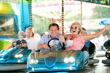 Senior couple in the bumper car at the fun fair