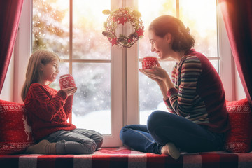 Wall Mural - mother and her daughter enjoying hot tea