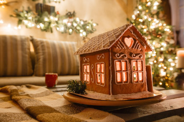 Wall Mural - Homemade gingerbread house on background room decorated for Christmas.