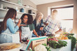 © Flamingo Images - Friends tasting food at table in kitchen