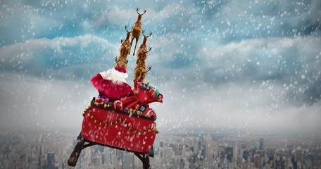 Poster - Composite image of rear view of santa claus riding on sled