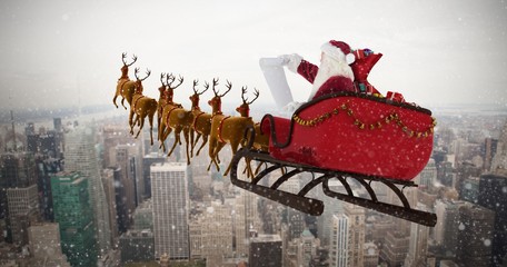 Wall Mural - Composite image of santa claus riding on sled during christmas