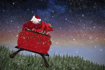 Poster - Composite image of rear view of santa claus riding on sled with 