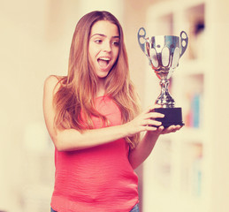 Wall Mural - young woman holding a trophy on a white background