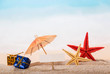 © laboko - Blank card, starfish, umbrella and gifts in sand against sea.