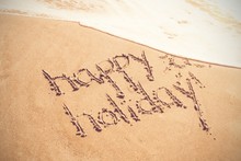Happy Holiday Written Text On Sand