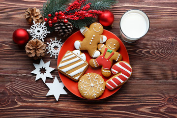 Wall Mural - Plate with tasty cookies, glass of milk and Christmas decor on wooden table