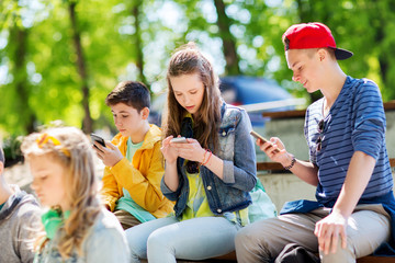 Canvas Print - happy teenage friends with smartphones outdoors