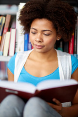 Canvas Print - african student girl reading book at library