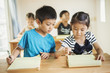 © Mint Images - Group of children in classroom, working together