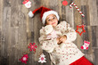 © javiindy - Adorable little girl wearing santa hat laying on wooden floor
