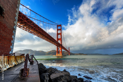 Golden Gate Bridge in San Francisco on a partly cloudy day Poster