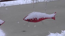 Wooden Red Fish Shaped Decorations During Snow Storm Near Pond