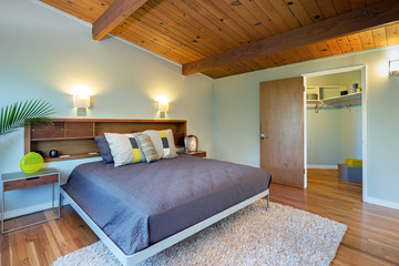 Bedroom interior with wooden ceiling and decorated closet.