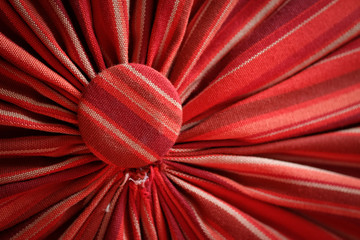 Pleated fabric red with head studs close up, abstract background texture