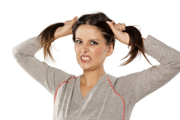 portrait of a cute angry woman holding her hair in two tails